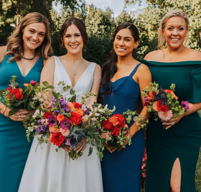 A bride and her friends holding Poppy’s wedding bouquets in jewel tones