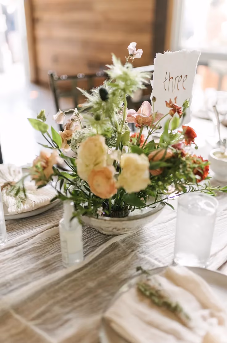 An Ikebana centerpiece on a dining table at a wedding.