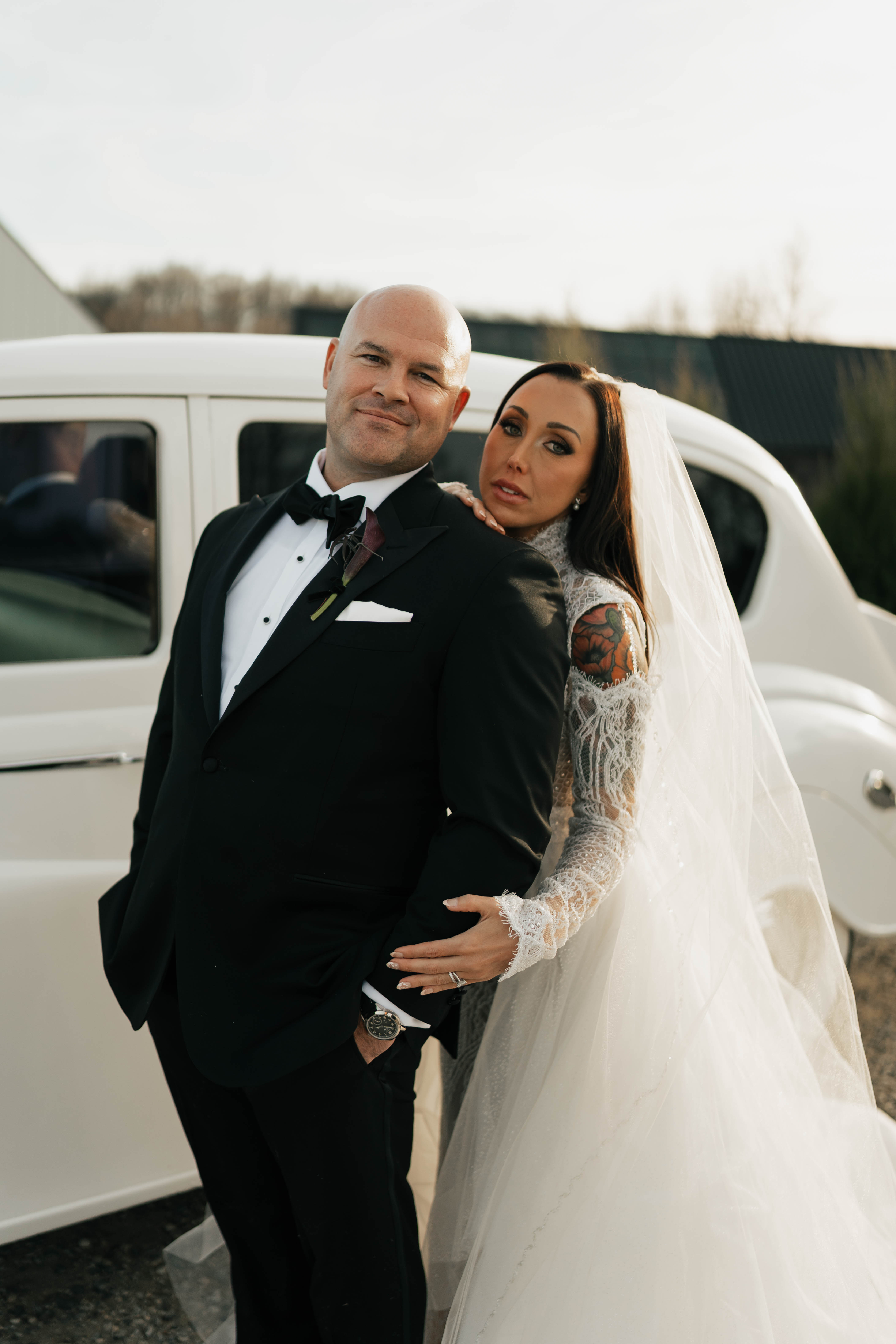Couple portrait at intimate fall celebration with dark burgundy floral design