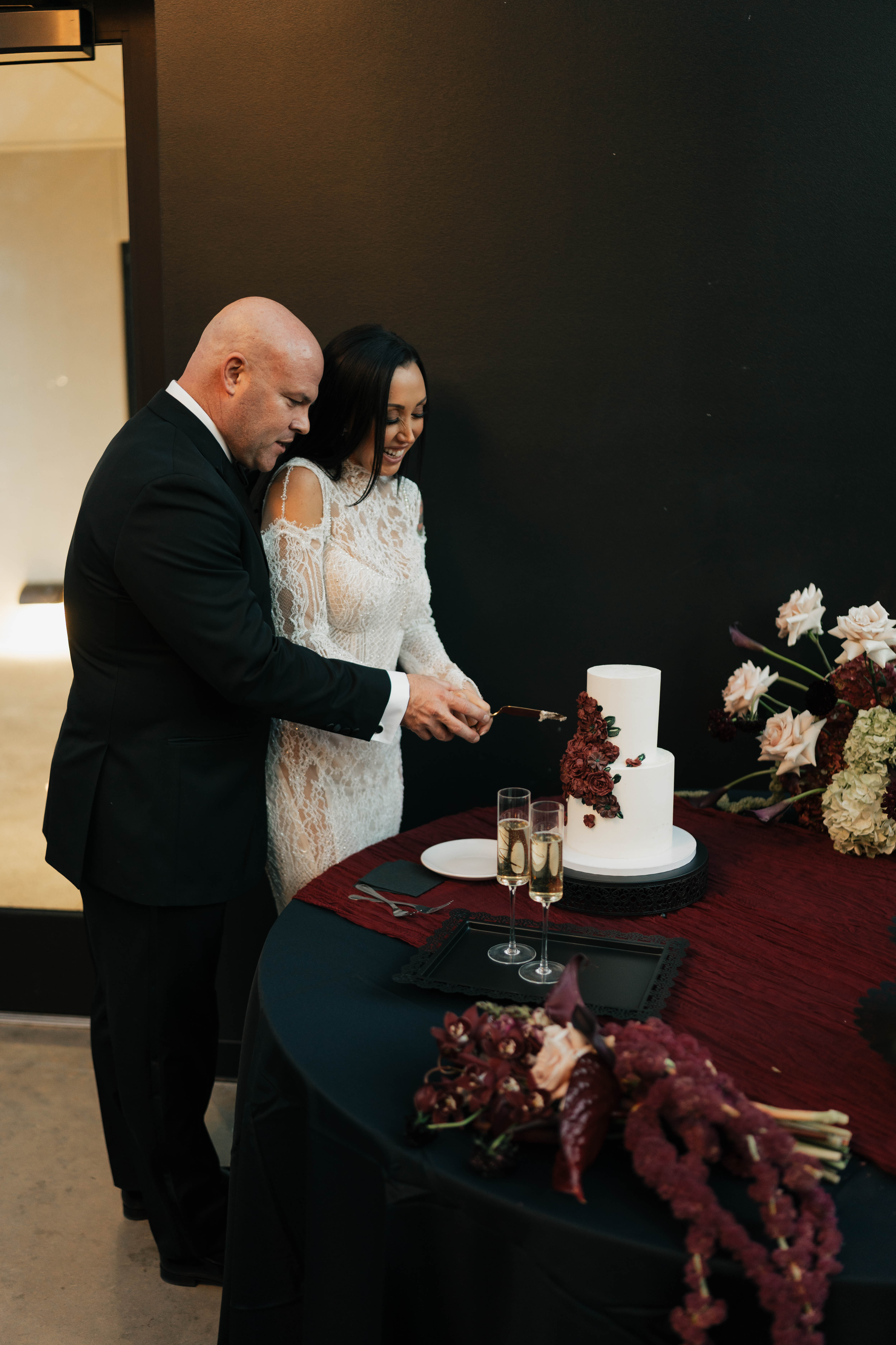 Bride and groom celebrating at intimate fall wedding with moody romantic floral design by Poppy Flowers