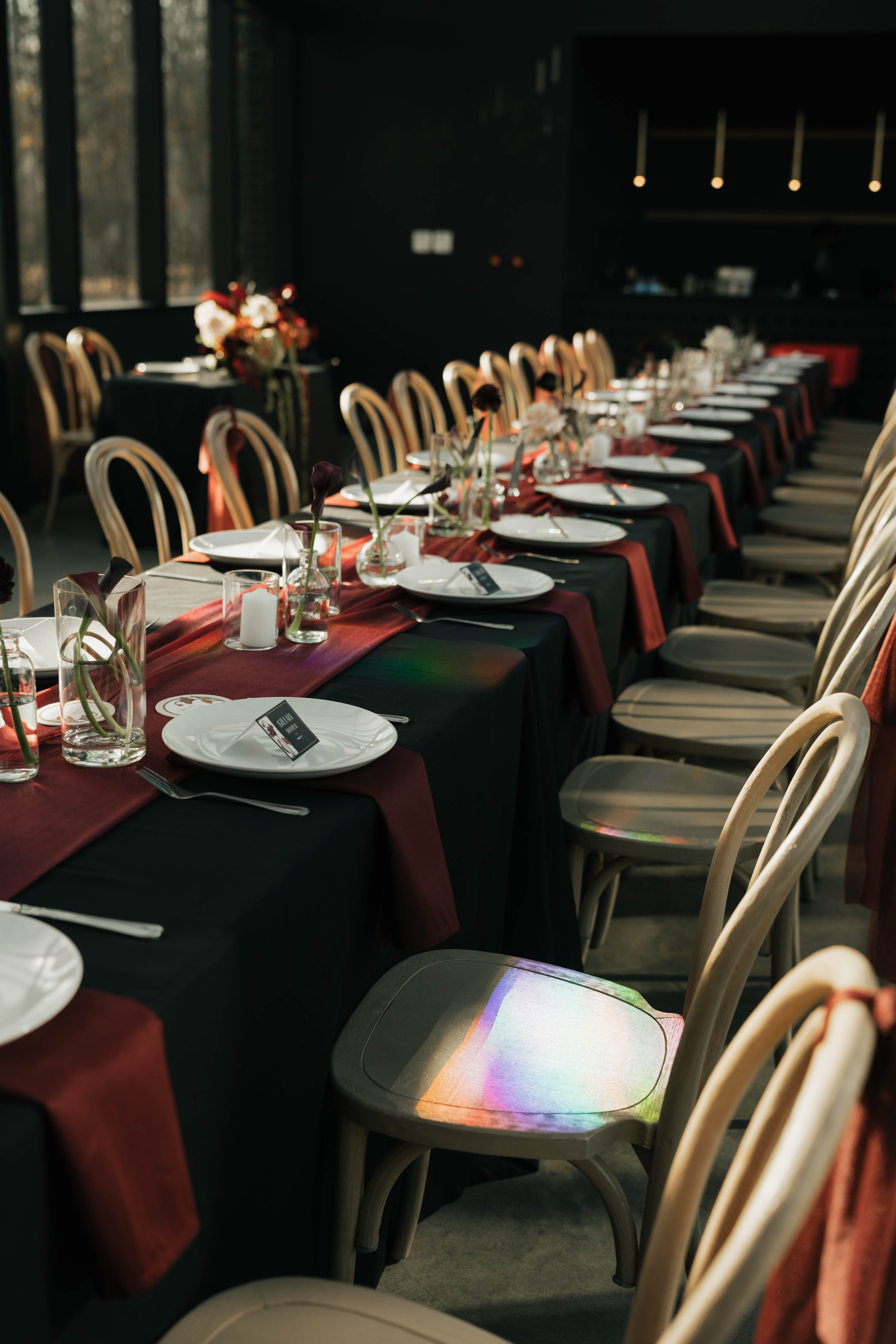 Wedding reception floral design with burgundy calla lilies and cream roses at modern venue