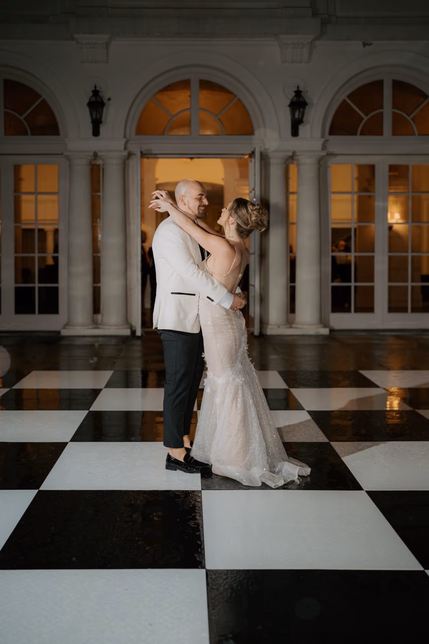 Couple dancing in rain at night with dramatic lighting at Connecticut wedding