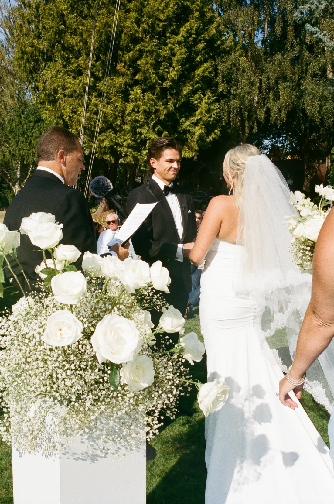White rose and baby's breath pedestal arrangements at an outdoor Seattle Yacht Club ceremony